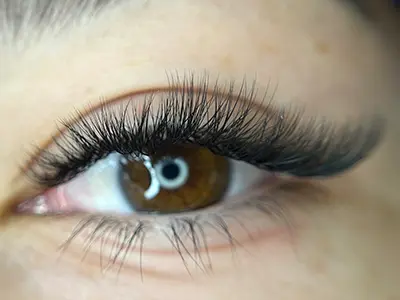 Mega Volume lash extensions creating a full and dramatic look for enhanced beauty.